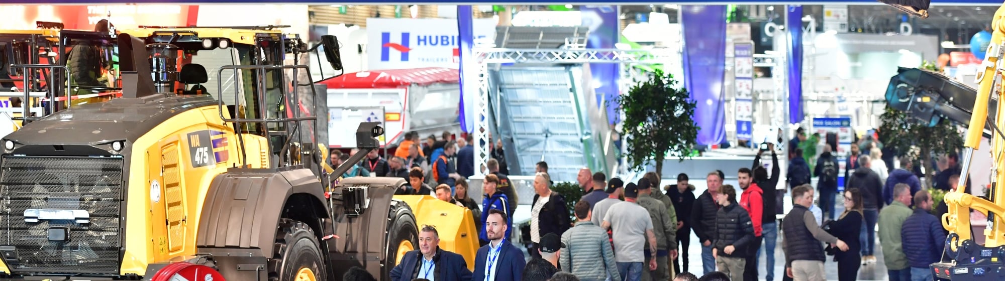 Large construction machine displayed with visitors around at a trade show