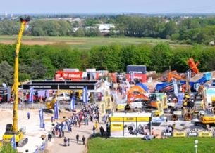 Zone extérieure avec machines et équipements de chantier, visiteurs présents